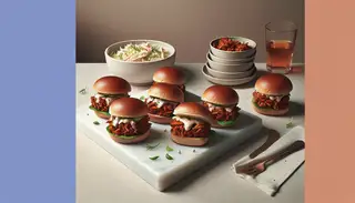 Image of vegan BBQ pulled jackfruit sliders on a minimalist table, featuring smoky jackfruit and vegan coleslaw in toasted buns.