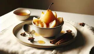 Elegant vegan pear and ginger compote in a small bowl, with syrupy, spiced pear slices on a clean, simple table.