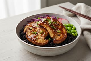 Miso-maple glazed Lion’s Mane katsu on black rice with edamame and radish in a minimalist bowl. Serene wabi-sabi Japanese vegan food photography.