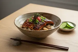 Charred miso-glazed Lion's Mane 'Kabayaki' over sushi rice in a ceramic bowl with scallions and ginger. Minimalist Japanese food photography.
