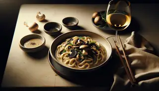 Elegant vegan creamy mushroom and truffle oil udon on a minimalistic table setting, highlighting the dish's luxurious creaminess.