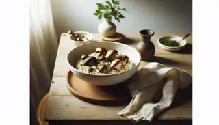 Elegant vegan mushroom risotto in a white bowl on a wooden table, featuring shiitake, portobello, and button mushrooms, garnished with parsley, next to a linen napkin and a leaf in a vase.