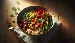High-resolution image of an African-Asian fusion sorghum bowl with sweet potatoes, red bell peppers, and edamame, garnished with cilantro and sesame seeds on a wooden table.