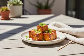 Charred Miso-Peach Glazed Tofu Burnt Ends with a sticky glaze, scallions, and sesame seeds. Vibrant vegan Asian-American BBQ fusion.