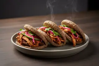 Artisanal teff bao buns filled with spicy Suya pulled mushrooms, neon-pink pickled onions, and cilantro on a minimalist ceramic plate.