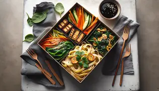 Vegan Bento-Inspired Pasta Box on a minimalist table, featuring handmade pasta, tempeh, vegetables, miso-soy sauce, sesame seeds, and cilantro in natural light.