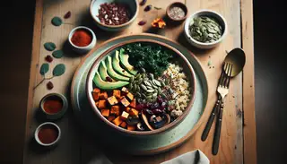 Vegan breakfast bowl with quinoa, sweet potatoes, and kale, topped with avocado and seeds, on a wooden table under soft light.