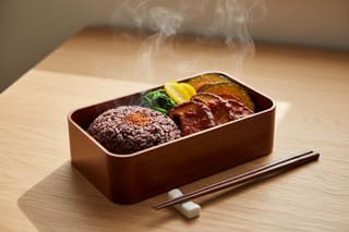 Minimalist bento with red-glazed mushrooms, black rice, and roasted kabocha in a dark wood box. Rising steam and elegant Japanese aesthetic.
