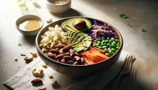 A vibrant Nutty Vegan Buddha Bowl with quinoa, nuts, avocado, and veggies, drizzled with tahini and sesame seeds, bathed in natural light.