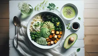 Serene breakfast setup with a quinoa bowl topped with cucumber, avocado, seaweed salad, tofu, and herbs, beside a dressing glass, in natural light.