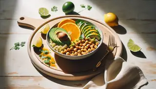 Vegan millet and chickpea bowl with orange segments, avocado, and citrus zest on a minimalist wooden table, highlighted by bright sunlight.