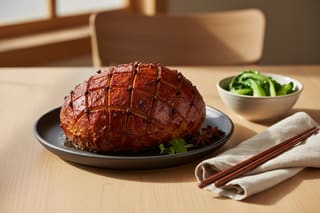 Glossy mahogany Gochujang glazed vegan roast with diamond scoring on a minimalist charcoal platter, garnished with micro-shiso and bok choy.