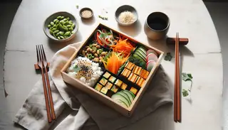 Vegan bento box with sushi rice, marinated tofu, colorful vegetables, pickled radish, edamame, garnished with sesame seeds, nori flakes, and cilantro on a simple table.